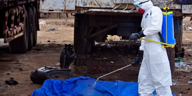 Aug. 12, 2014: The body of a man found in the street, suspected of dying from the Ebola virus, is sprayed with disinfectant in the capital city of Monrovia, Liberia.