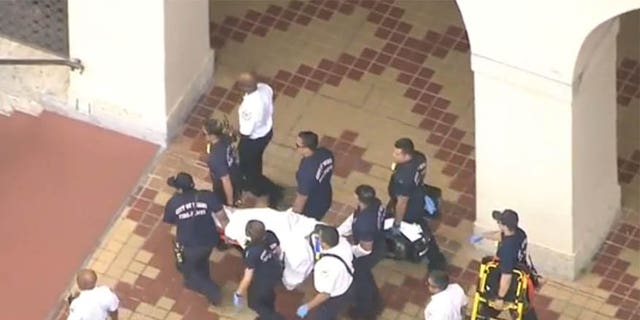 May 3, 2017: An injured suspect is carried away by responders after shots were fired inside the Miami-Dade Library.