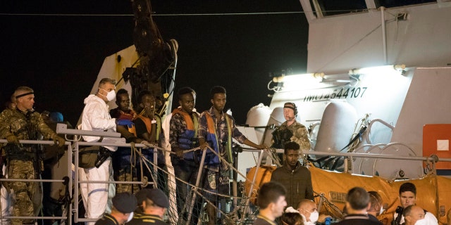 Migrants desembark from Frontex ship "Protector" at the port of Pozzallo, Sicily, Italy, in the early hours of Monday, July 16, 2018.