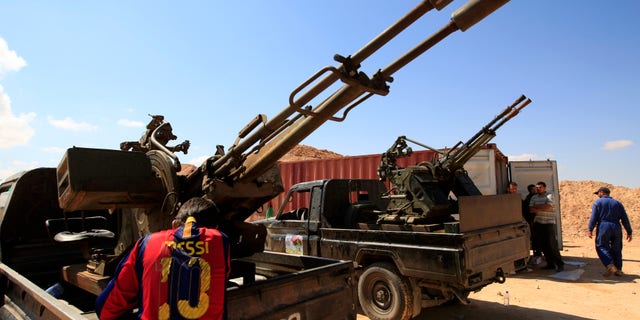 Tuesday: A Rebel fighter wearing FC Barcelona soccer player Lionel Mess T-shirt stands next to his heavy weapon, preparing for clashes with pro-Muammar al-Qaddafi forces at the front line of Dafniya, about 25 miles west of Misrata, Libya.