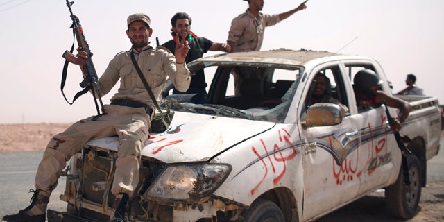 Sept. 19: Former rebel fighters arrive from inside Bani Walid with a pickup truck allegedly captured from Gadhafi loyalists, at the northern gate of the city, Libya.
