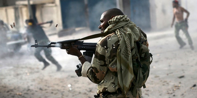 Oct. 19, 2011: A Libyan rebel fighter fires his machine gun toward loyalist positions down town Sirte, Libya.