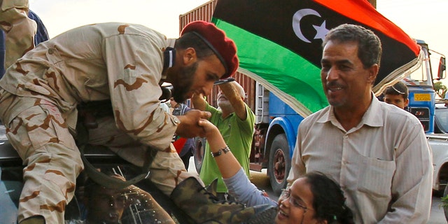 OCt. 22, 2011: A Libyan revolutionary fighter returning from Sirte is welcomed at Al Guwarsha gate in Benghazi, Libya.