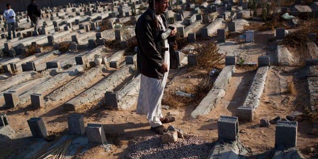 May 26: Faissel Omran Dehik stands next to the tomb of his brother who was killed a week ago during fighting against Qaddafi forces on the outskirts of Misrata, Libya. For the first time, pro-Qaddafi forces expressed interest to speak with the rebels.