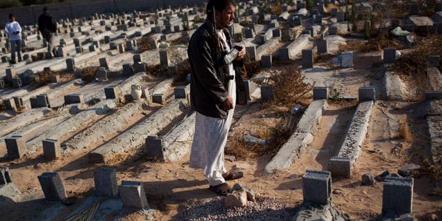 May 26: Faissel Omran Dehik stands next to the tomb of his brother who was killed a week ago during fighting against Qaddafi forces on the outskirts of Misrata, Libya. For the first time, pro-Qaddafi forces expressed interest to speak with the rebels.
