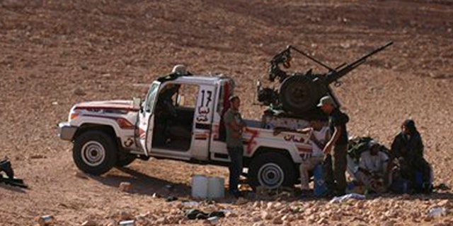 Former rebel fighter and engineering student Ahmed Hamza, 23, left, prays on the outskirts of Bani Walid, Libya, Sunday, Sept. 11, 2011. Libyan fighters are signing up for a final assault on one of the last remaining bastions of Muammar Qaddafi.