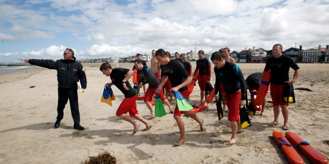 May 15: Lifeguard captain Arn Van Dyk, left, directs lifeguard trainees in a swimmer-rescue drill during a training session for new seasonal lifeguards at Newport Beach, Calif. Newport Beach’s 13-member, full-time lifeguard crew has gotten skeptical reactions ever since the local newspaper editorialized about lifeguard salaries, benefits and overtime pay that in at least two instances top $200,000 as the city struggles to rein in pension costs. (AP)