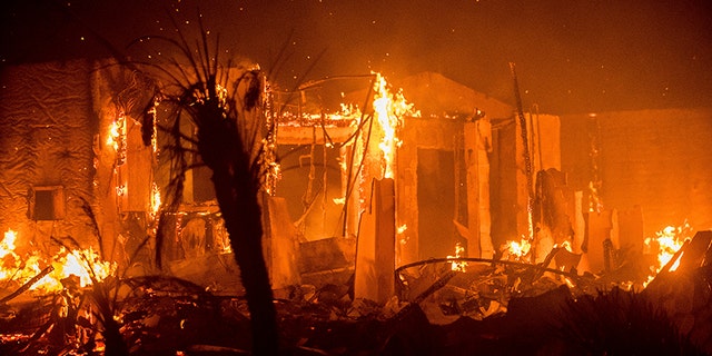 Flames consume a structure as the Lilac fire burns in Bonsall, Calif.