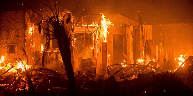 Flames consume a structure as the Lilac fire burns in Bonsall, Calif.