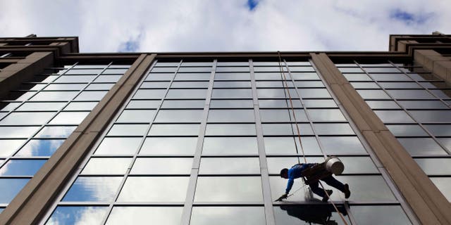 FILE - In this April 23, 2015 file photo, a window washer cleans the windows of an office building in downtown Washington. The U.S. government issues the May jobs report on Friday, June 5, 2015. (AP Photo/Pablo Martinez Monsivais, File)