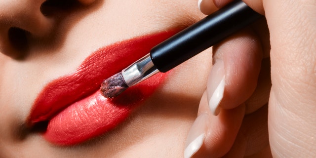 woman applying lipgloss on lips