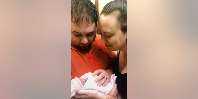 Jenny Rogers and her husband Hal holding their newborn daughter, Everly, before she died at 6 days old.
