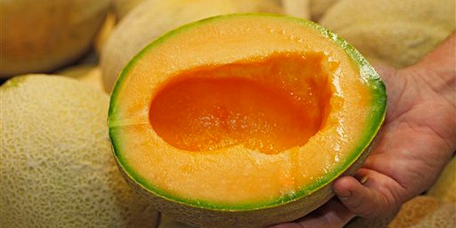 July 13, 2012: Produce manager Nate Codina holds a cut Rocky Ford cantaloupes at a Denver Kings Soopers market.