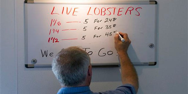 June 28, 2012: Bob Coppersmith updates the price board at Dock's Seafood Restaurant in South Portland, Maine. Many stores are selling the king of seafood for under $5 a pound, making it cheaper than bologna by weight.