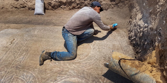 Uncovering the mosaic. (Photo: Amir Gorzalczany, Israel Antiquities Authority)