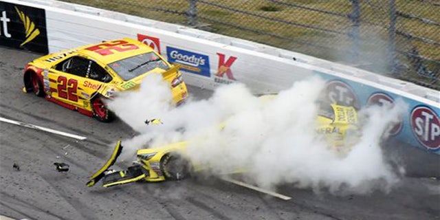 Joey Logano (22) and Matt Kenseth (20) tangle in Turn 1 during the NASCAR Sprint Cup Series auto race at Martinsville Speedway in Martinsville, Va., Sunday, Nov. 1, 2015. (AP Photo/Don Petersen)
