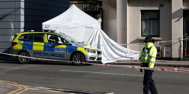 A police officer stands guard at the scene where a man died from stab wounds on the night of April 4, 2018, on Link Street in east London, Britain, April 5, 2018.