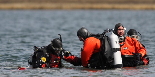 Suffolk County dive team police officers search for possible victims of a suspected serial killer in this April 14, 2011 file photo.