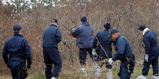 Emergency personnel search through the brush for human remains near Jones Beach in Wantagh, N.Y. in this April 11, 2011 file photo.