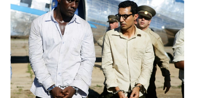 This photo released by The Weinstein Company shows Idris Elba, left, as Nelson Mandela, and Riaad Moosa, as Ahmed Kathrada, in the film, "Mandela: Long Walk to Freedom." (AP Photo/The Weinstein Company, Keith Bernstein)