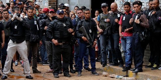 Police officers and criminal investigators look for evidence in front of a bakery after it was looted in Caracas, Venezuela April 21, 2017.