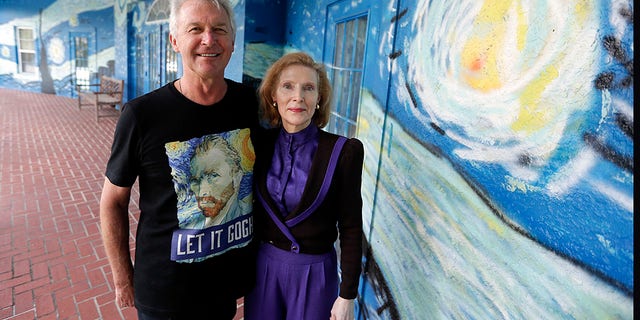 Lubomir Jastrzebski and Nancy Nemhauseer stand by a section of a mural at their home in Wednesday, July 18, 2018, in Mount Dora, Fla.