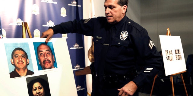 Feb. 6, 2017: Los Angeles police Sgt. Jack Richter displays photos of arson suspects from a 1993 fire prior to a news conference in Los Angeles