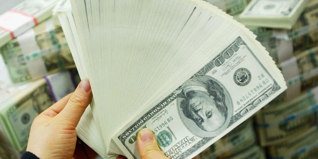 SEOUL, SOUTH KOREA - FEBRUARY 22: A South Korean banker carries US dollar bank notes at the Korea Exchange bank on February 22, 2005 in Seoul, South Korea. The South Korean won jumped to its highest intraday level in more than seven years in domestic trade on Tuesday, boosted by strong foreign equity buying and exporter deals. (Photo by Chung Sung-Jun/Getty Images)