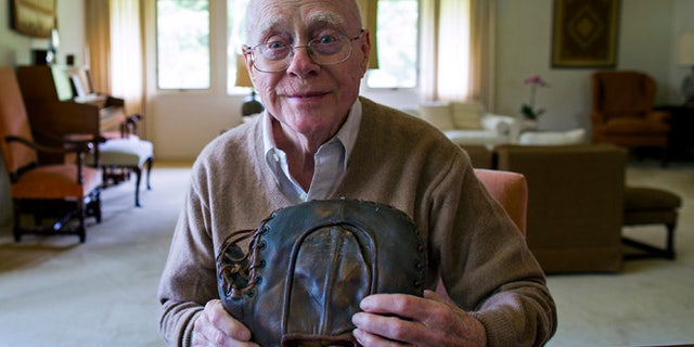June 30, 2014: Howard Henderson, who as a boy in New York played catch with baseball legend Lou Gehrig, holds a signed baseman's mitt given to him by Gehrig when he was young, at Henderson's Greenwich, Conn., home.