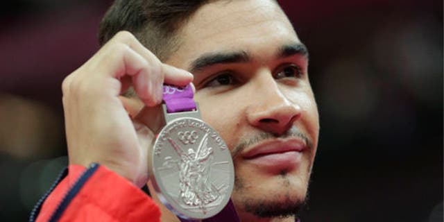 Louis Smith displays his silver medal during the artistic gymnastics men's pommel horse finals at the 2012 Summer Olympics.
