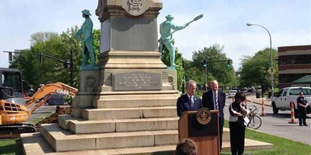 Louisville Mayor Greg Fischer speaks in front of the Confederate monument near the University of Louisville with university President James Ramsey, left, in Louisville, Ky., Friday, April 29, 2016. The Confederate monument capped with a statue of Jefferson Davis will be removed from a spot near the University of Louisville campus where it has stood since 1895. (AP Photo/Dylan Lovan)