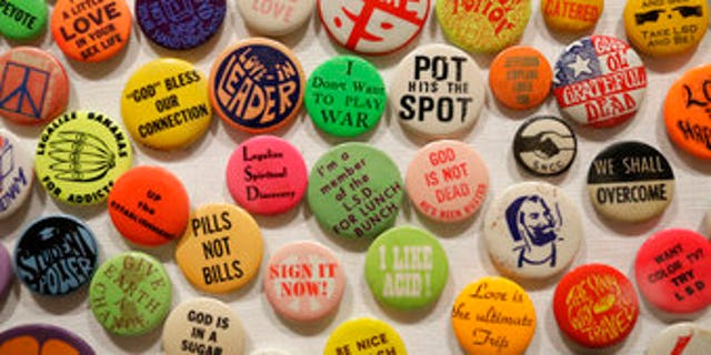 This Wednesday, May 10, 2017 photo shows a display of buttons in the exhibit "The Summer of Love Experience, Art, Fashion and Rock and Roll" in Golden Gate Park at the deYoung Museum in San Francisco. (AP Photo/Eric Risberg)