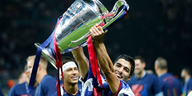 Barcelona's Luis Suarez and Neymar celebrates with the trophy after after the Champions League final soccer match between Juventus Turin and FC Barcelona at the Olympic stadium in Berlin Saturday, June 6, 2015. Barcelona won the match 3-1. (AP Photo/Frank Augstein)