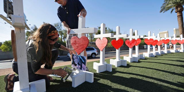 Sherri Camperchioli, left, and Jordan Cassel help set up some of the crosses that arrived in Las Vegas today to honor the victims of the mass shooting on Thursday, Oct. 5, 2017, in Las Vegas. A gunman opened fire on an outdoor music concert on Sunday killing dozens and injuring hundreds. (AP Photo/Gregory Bull)