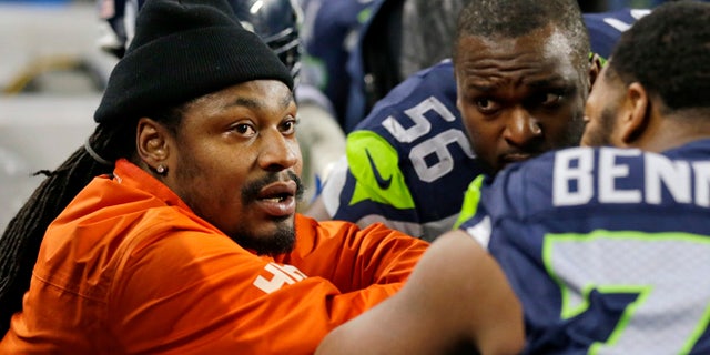 In this Dec. 4, 2016, file photo, retired Seattle Seahawks running back Marshawn Lynch, left, chats on the sidelines players on the bench in the second half of an NFL football game against the Carolina Panthers in Seattle.
