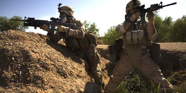 Navy corpsman Michael Lang, of Camden County, Ga., right, with an M-4 carbine, and Lance Cpl. Ard Bizahaloni of Pinon, Ariz., with an M-16 rifle, with the First Battalion, Sixth Marine Regiment, Alpha company, take up positions in Marjah, Afghanistan. The U.S. military's workhorse rifle, used in battle for the last 40 years, may be proving less effective in Afghanistan.