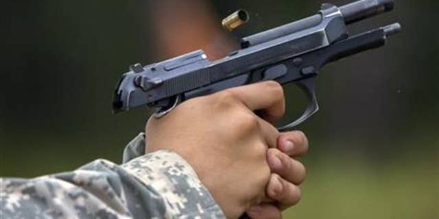 A 9mm case is ejected from the chamber of a Beretta M9 during a qualifying exercise for the 139th Military Police Company, Tuesday, Sept. 29, 2015, in Fort Stewart, Ga. The Army wants to replace its M9, a 9mm semi-automatic handgun adopted during the Cold War.