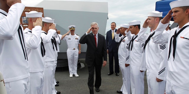 U.S. Secretary of the Navy Ray Mabus salutes servicemen as he leaves the USS Freedom littoral combat ship after his visit, at Changi Naval Base in Singapore May 11, 2013.
