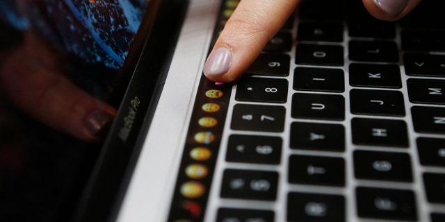 File photo: A guest points to a new MacBook Pro during an Apple media event in Cupertino, California, U.S. October 27, 2016. (REUTERS/Beck Diefenbach)