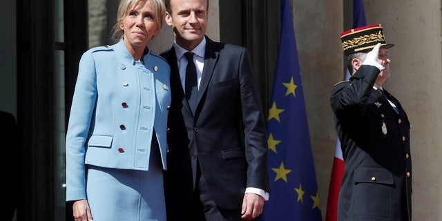 French President Emmanuel Macron and his wife Brigitte Trogneux stand on the steps of the Elysee Palace after the handover ceremony in Paris, France, May 14, 2017. REUTERS/Benoit Tessier - RTX35QXC