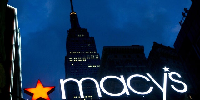 The Macy's logo is illuminated with the Empire State Building in the background