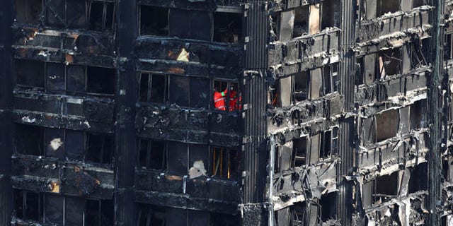 Members of the emergency services work inside burnt out remains of the Grenfell apartment tower in North Kensington, London, Britain, June 18, 2017. REUTERS/Neil Hall - RTS17KNS