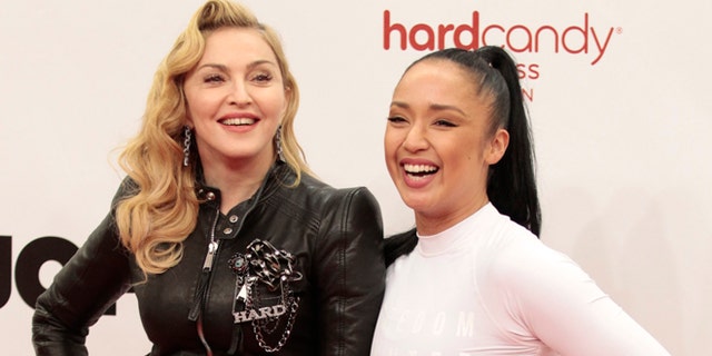 October 17, 2013. U.S. singer Madonna (L) poses with her personal fitness trainer Nicole Winhoffer to promote her latest gym in her Hard Candy Fitness centre chain in Berlin.
