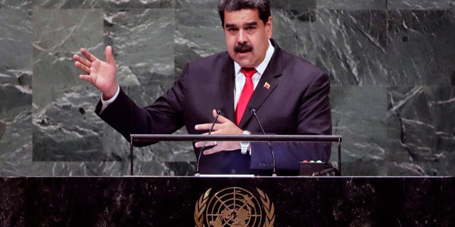 In this photo released by the Miraflores Press Office, Venezuela's President Nicolas Maduro, left, and his wife Cilia Flores greet supporters upon their arrival to a meeting with Colombian citizens that reside in Venezuela, In Caracas, Venezuela, Tuesday, Sept. 25, 2018. The Trump administration has slapped financial sanctions on four members of Venezuelan President Nicolas Maduro's inner circle, including his wife and the nation's vice president, on allegations of corruption. (Miraflores Press Office via AP)