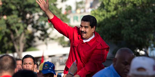 Venezuela's President Nicolas Maduro waves to supporters after the inauguration of cable car public transportation system, in the popular neighborhood of Petare, in Caracas, Venezuela, Tuesday, Dec. 1, 2015. (AP Photo/Ariana Cubillos)