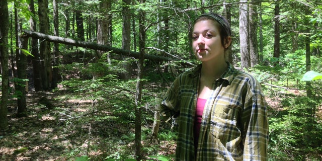 Rachel Borch, 21, stands in the woods near her home in Hope. Borch was attacked while on a jog in woods near her home by a rabid raccoon and had to drown the animal in self defense. (Alex Acquisto, Bangor Daily News)