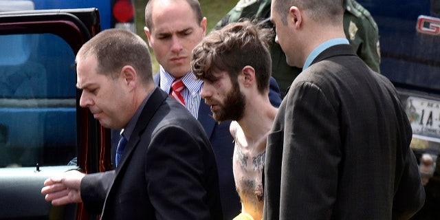 Maine State Police detectives lead John Williams to a police cruiser Saturday, April 28, 2018, on Norridgewock Road in Fairfield, Maine, following a four-day manhunt.
