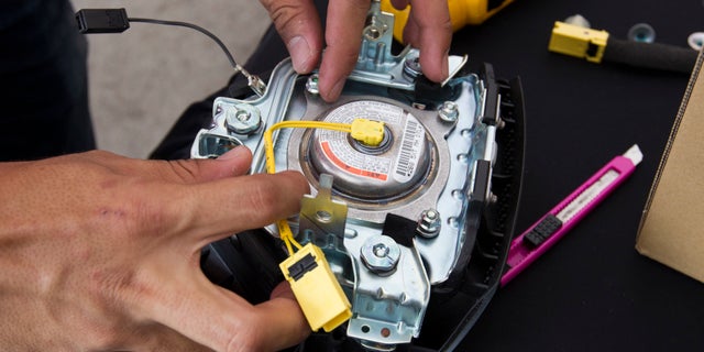 In this Sunday, Nov. 20, 2016, photo, a Honda technician works on an air bag inflator during a free air bag replacement event in Kuala Lumpur, Malaysia. Five Malaysians have died in accidents linked to faulty Takata air bags that are at the center of one of the worldâs largest auto recalls. (AP Photo/Lim Huey Teng)