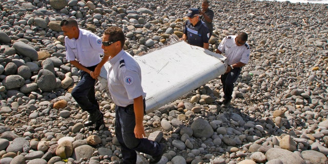 July 29, 2015: French police officers carry a piece of debris from a plane known as a flaperon in Saint-Andre, Reunion Island. The barnacle-encrusted part was the first trace found of Malaysia Airlines Flight 370, which disappeared two years ago.