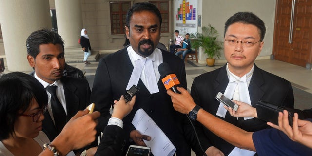 Oct. 31, 2014: Malaysian lawyer Arunan Selvaraj, center, speaks to journalists outside a courthouse in Kuala Lumpur, Malaysia.